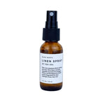 A travel size Slow North linen spray bottle with a label reading 'LINEN SPRAY OF THE SEA'.