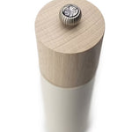 White salt grinder with a wood top with metal logo button on a white background