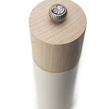 White salt grinder with a wood top with metal logo button on a white background