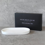 White catchall tray in front of a black Murchison-Hume box on a gray surface
