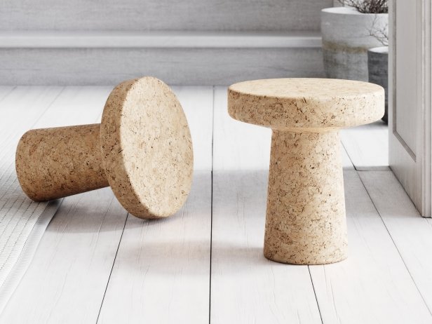 Cork Stool Model C in a room with greyish walls and floor, with another stool resting on its side.