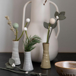 green and white flower stems in small vases