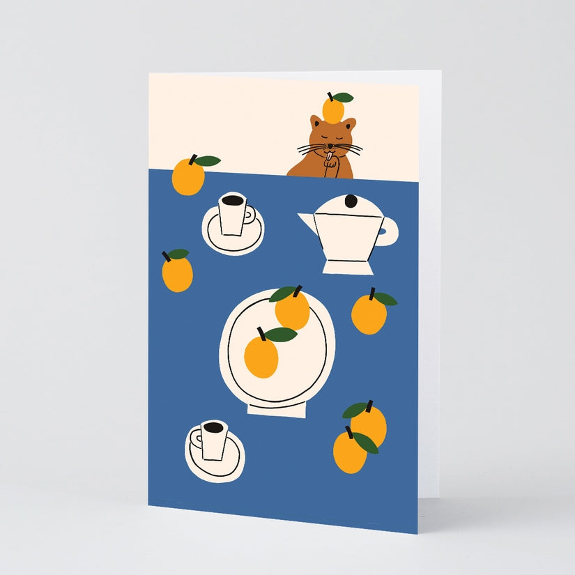 Art Greeting Card with Cat and Oranges in front of a table.