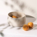 gharyan large stoneware serving bowl in matte white with oranges on table