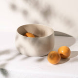 gharyan large stoneware serving bowl in matte white with oranges on table