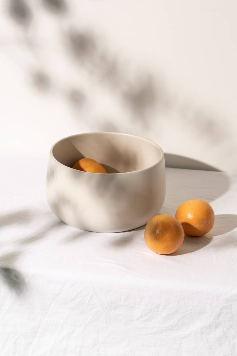 gharyan large stoneware serving bowl in matte white with oranges on table