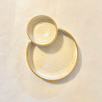 Ceramic speckled serving bowl with a smaller bowl attached, displayed on a plain background.