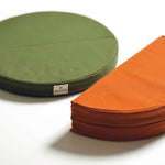 snow peak cushions in green and orange. green cushion is unfolded and the orange is folded in half. 