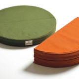 snow peak cushions in green and orange. green cushion is unfolded and the orange is folded in half. 