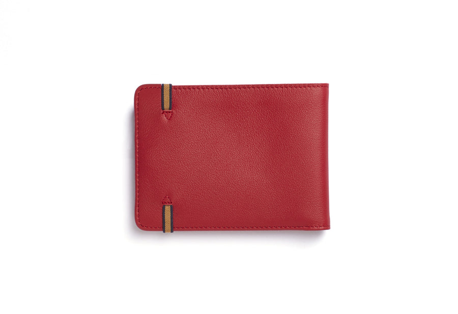 Back view of red leather rectangular wallet, with light brown and black elastic ends stitched onto wallet.