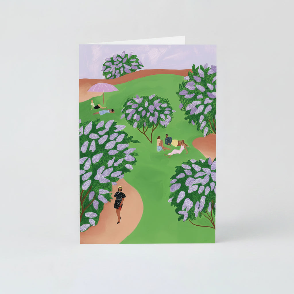 A greeting card depicting a hand-painted scene with lilac bushes and a sky of the same color, with people in a park pathway.