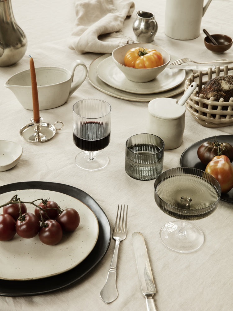 grey rippled glass drinkware with white ceramic plates on table 