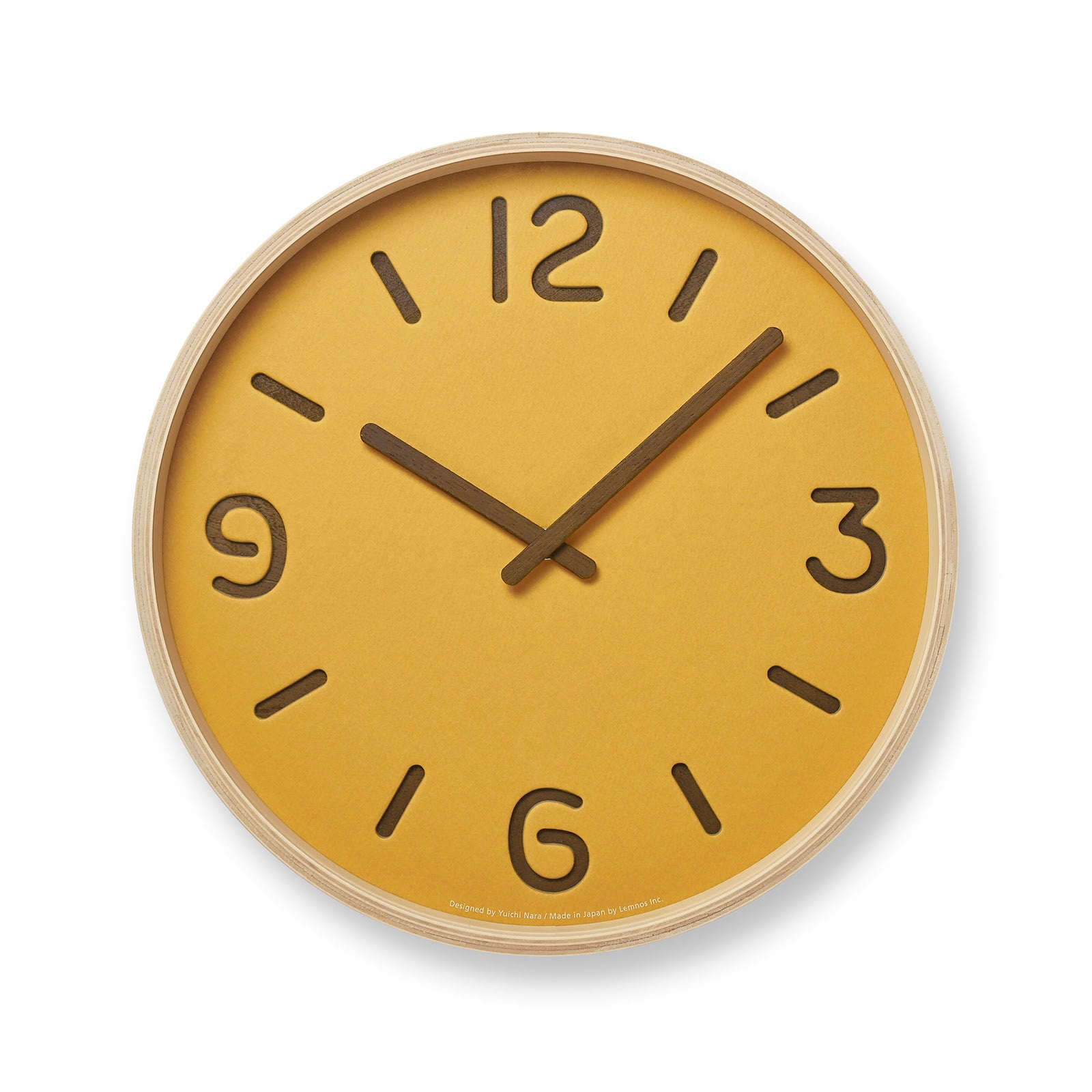 A yellow wall clock with a wooden frame and paper face, designed by Yuichi Nara.